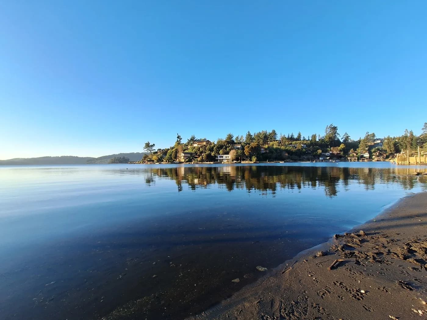 Orilla del Lago Vichuquén reflejando los cerros al amanecer