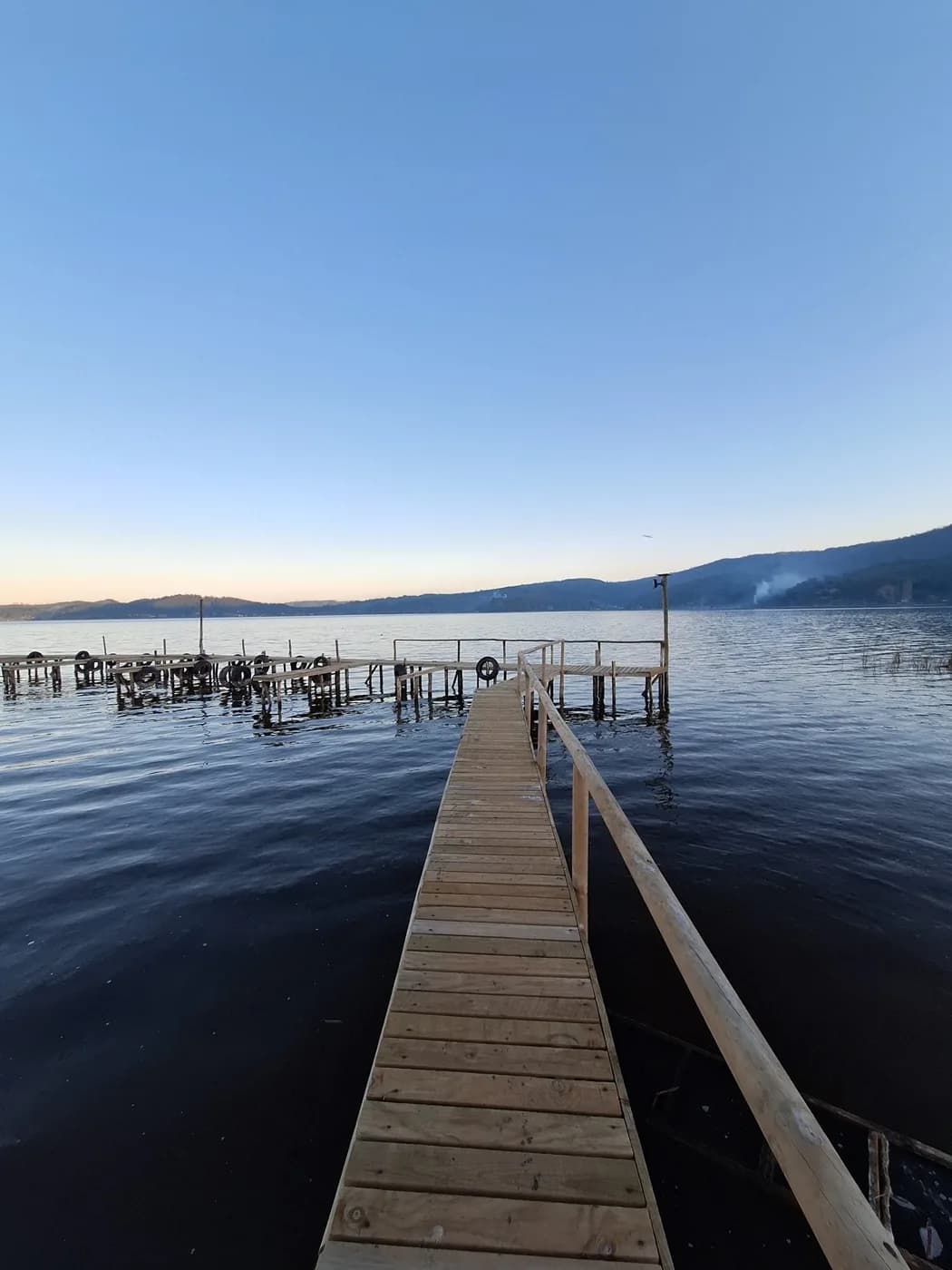 Muelle de madera de La Reserva adentrándose en el Lago Vichuquén al atardecer