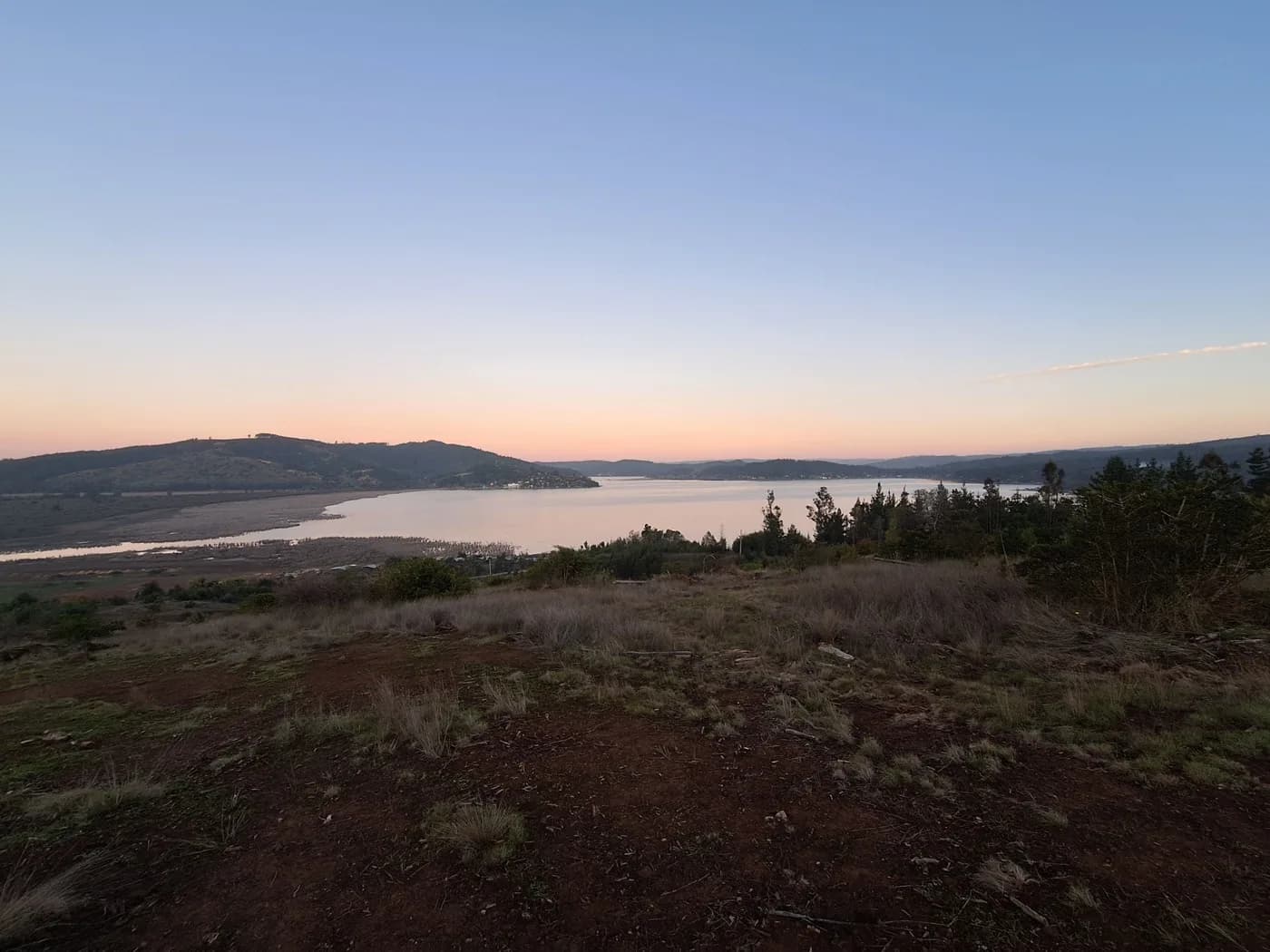 Vista elevada del Lago Vichuquén al atardecer desde el terreno de La Reserva